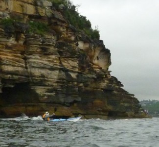 Timbo paddling along the cliff at Middle Head