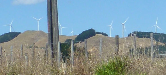 Wind farm turbines can be seen overlooking the town of Raglan